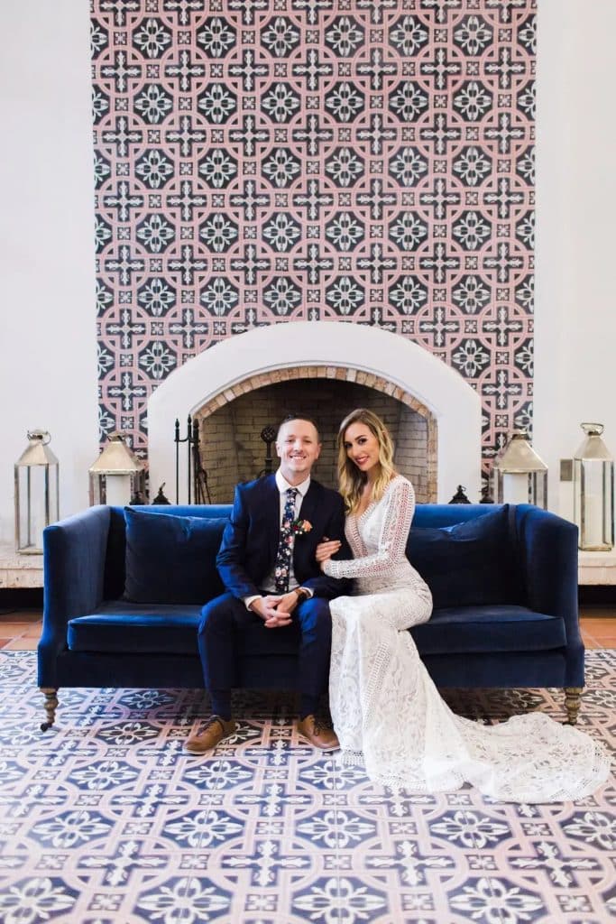 bride and groom sitting on blue couch with tile backdrop and tile floor at La Cita Country Club
