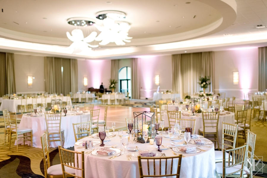 soft pink and white wedding reception with round tables and pink uplights at Omni Orlando Resort at Champions Gate