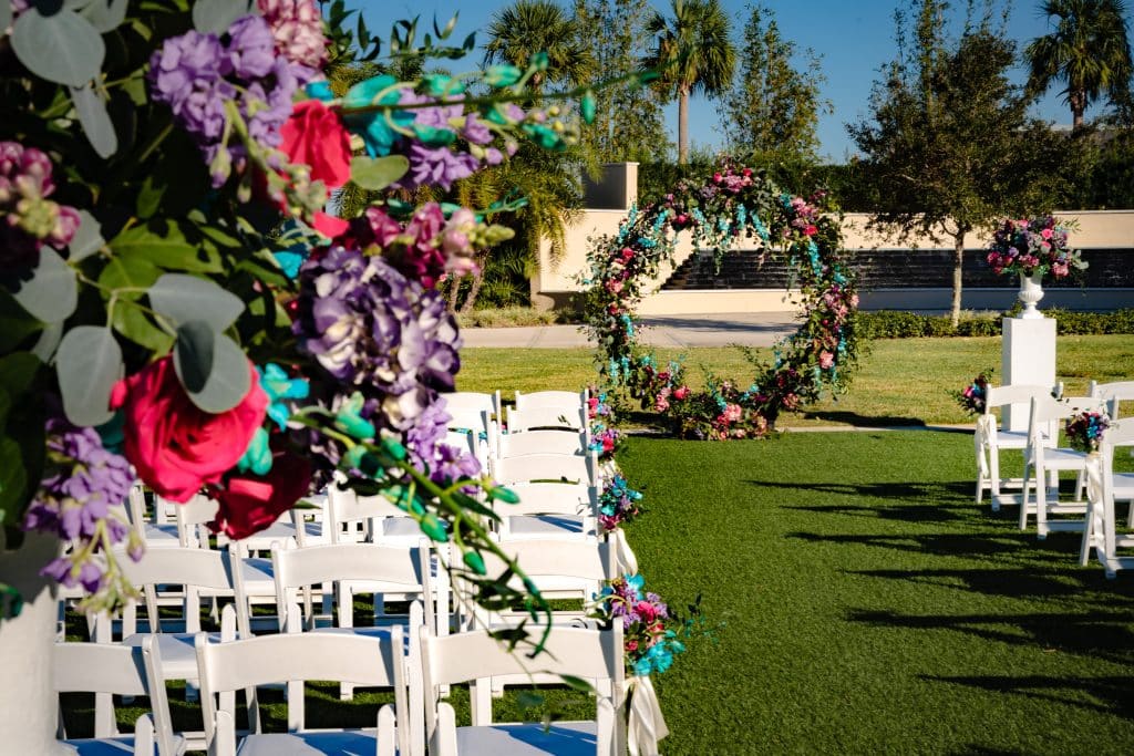 vibrant pink and lavender floral arches at outdoor wedding ceremony site at Omni Orlando Resort at Champions Gate