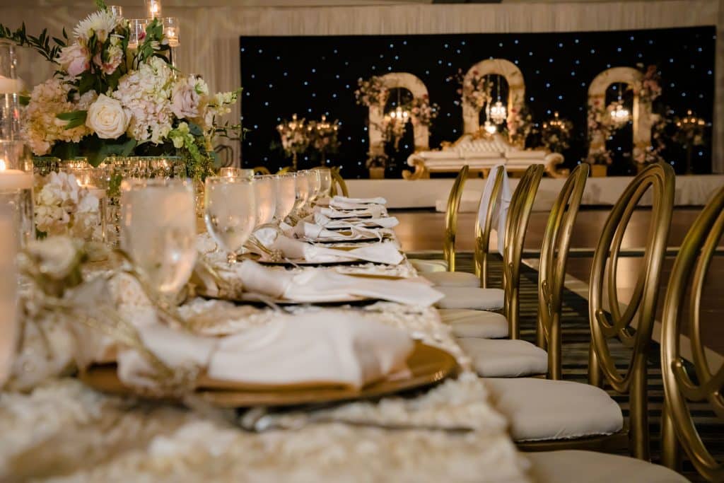 long wedding reception table with gold and white accents at Omni Orlando Resort at Champions Gate