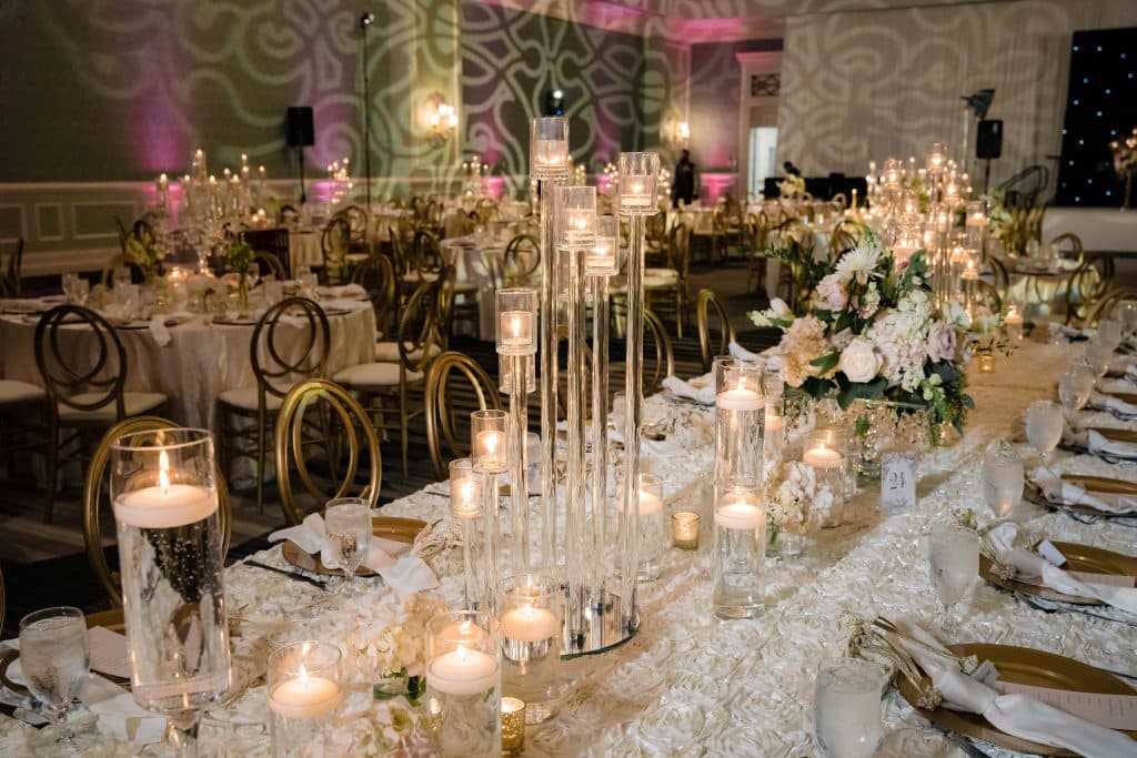 floating candle centerpieces along long white tablecloth with gold accents at Omni Orlando Resort at Champions Gate
