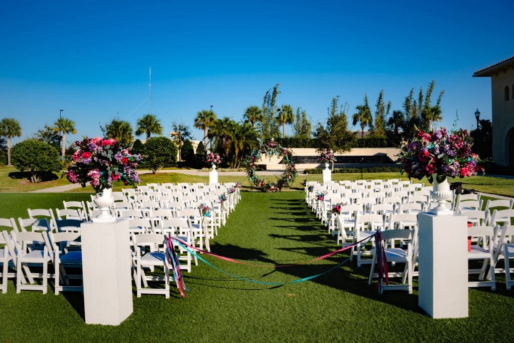 outdoor ceremony site with white chairs along grass aisle at Omni Orlando Resort at Champions Gate