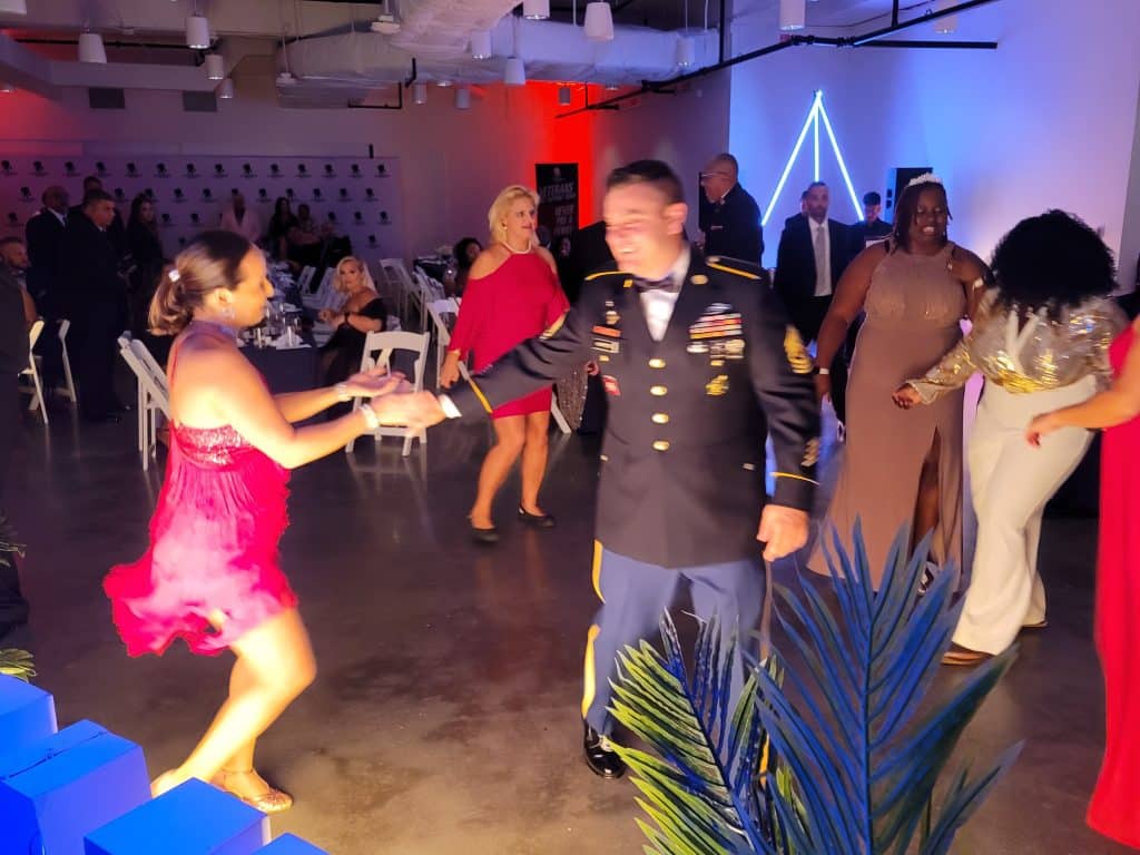 man in uniform dancing with woman at a party