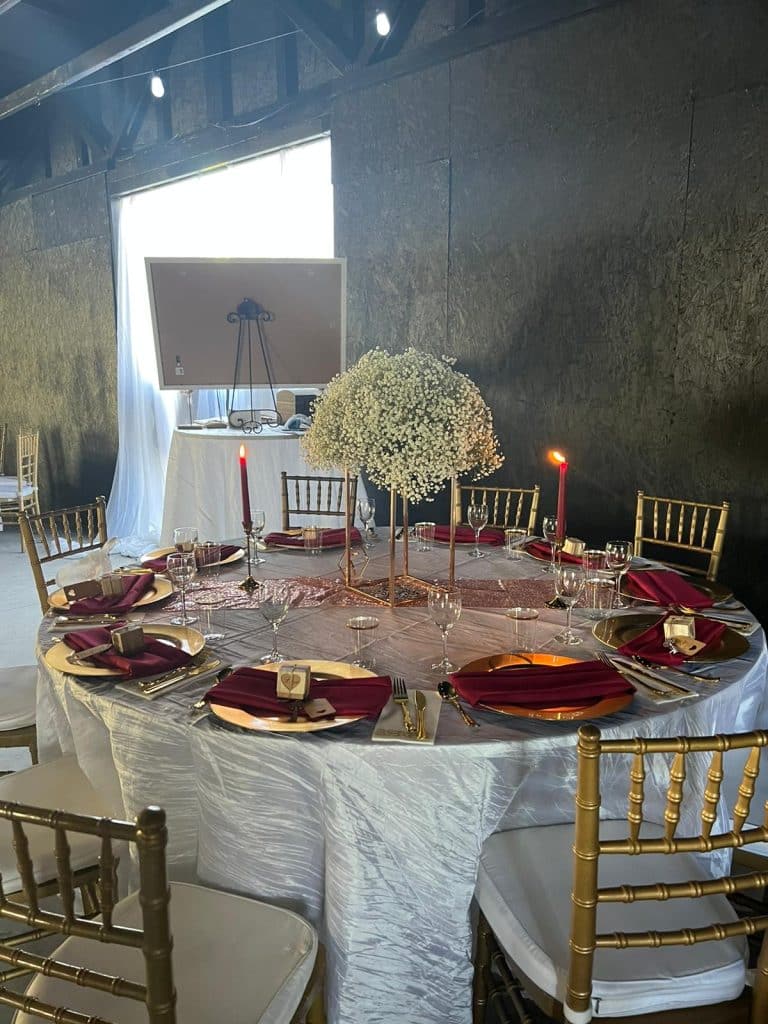 round tables with gold chargers and Chiavari chairs and white floral centerpieces planned by Soulovevent LLC