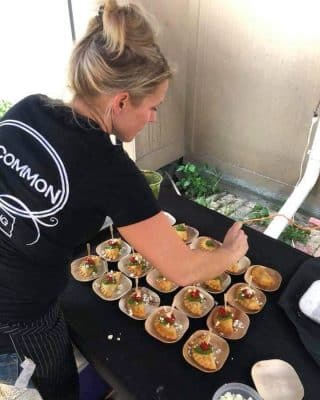 Uncommon Catering getting delicious food table ready for wedding