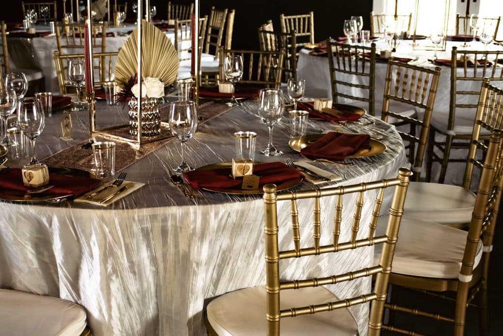 gold Chiavari chairs with metallic linens and gold candles planned by Soulovevent LLC