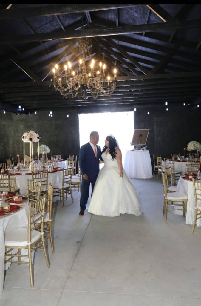 bride and groom under chandelier in post and beam veue planned by Soulovevent LLC
