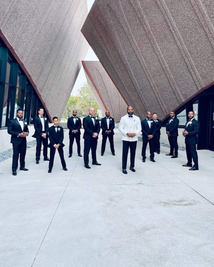 groom and groomsmen standing in outdoor foyer of modern buildings at the Winter Park Events Center