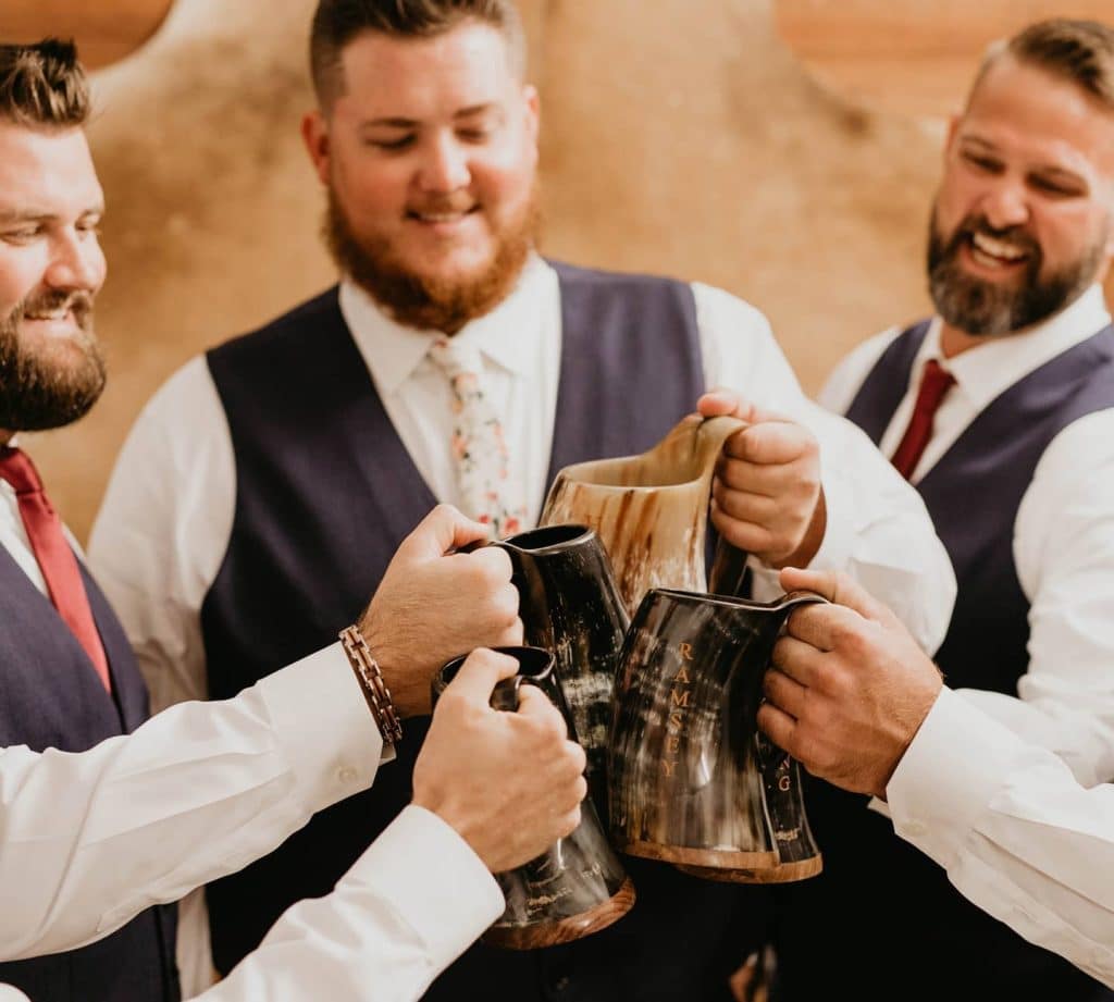 groom and his groomsmen toasting from horn chalice before wedding coordinated by Julie Miner Events