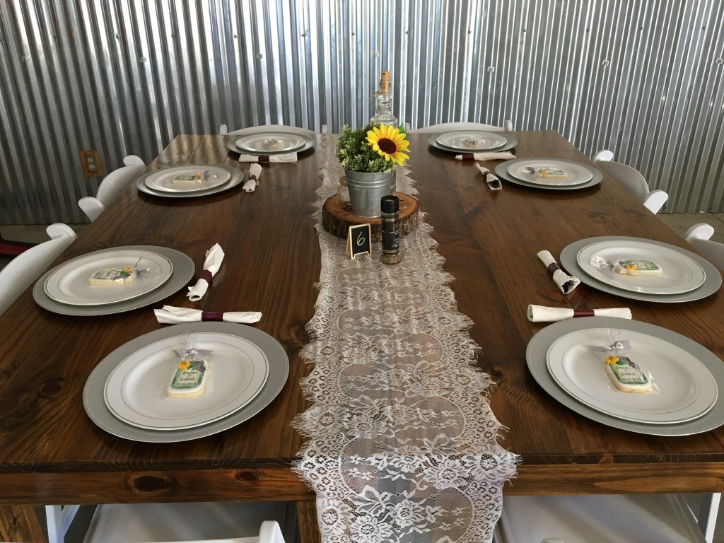 square wooden table with lace table runner and black eyed Susan centerpieces at The Red Barn at Bushnell
