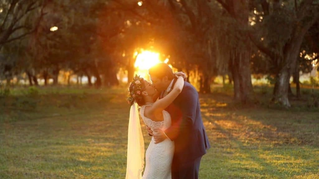 bride and groo kissing as the sun sets at The Red Barn at Bushnell