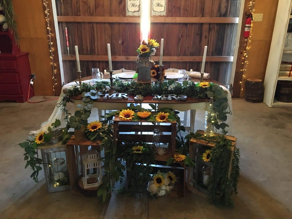 sweetheart table with black eyed Susan flowers and lanterns at The Red Barn at Bushnell