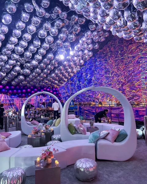 modern loveseats under ceiling of metallic bubbles against pink and purple tinted wall from Bubble Design Rentals Orlando