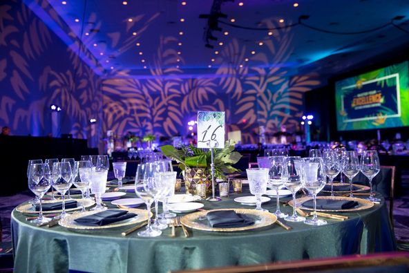 dusty turquoise linen draped table with blue uplighting and lime green screen from Bubble Design Rentals Orlando