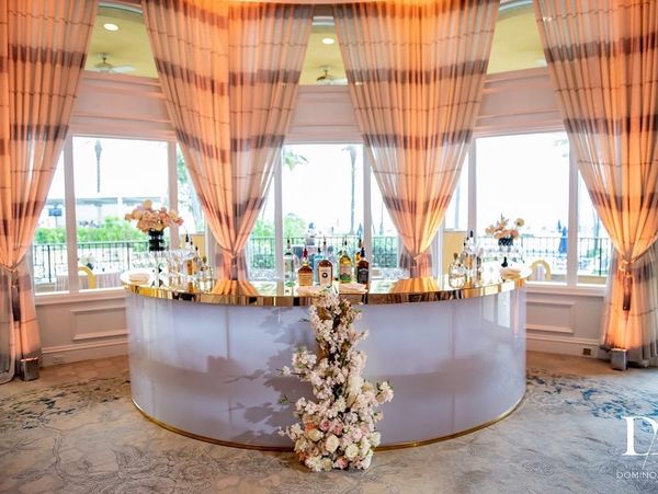 large white and gold reception table with drapes against a window wall from Bubble Design Rentals Orlando