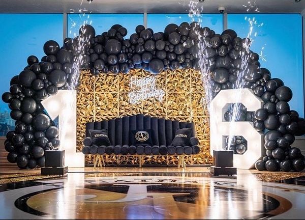 sweet sixteen black couch with black balloon wall and confetti cannons by Bubble Design Rentals Orlando