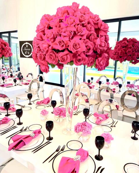 tall dark pink roses centerpieces with pink table napking and black wine glasses and cutlery by Bubble Design Rentals Orlando