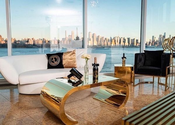 modern and contemporary seating area with gold coffee table against city skyline by Bubble Design Rentals Orlando