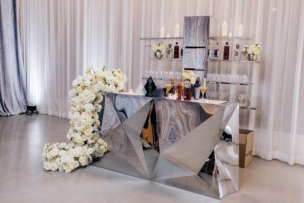 glass and silver bar set up with white bouquets of draping flowers by Bubble Design Rentals Orlando