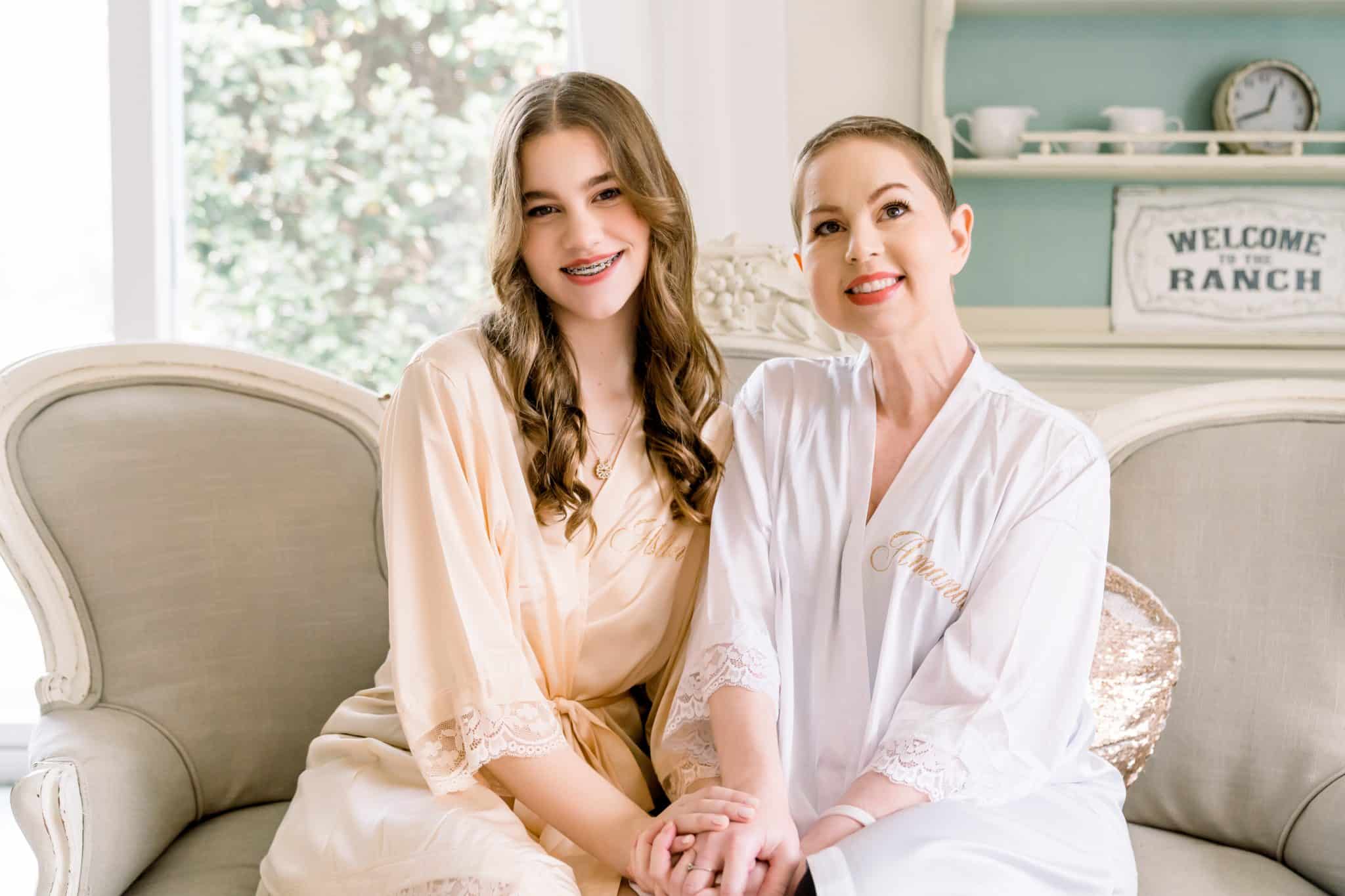 Before the wedding, mother and daughter pose for a photo in their getting ready robes after having their hair and makeup done by M3 Beauty.