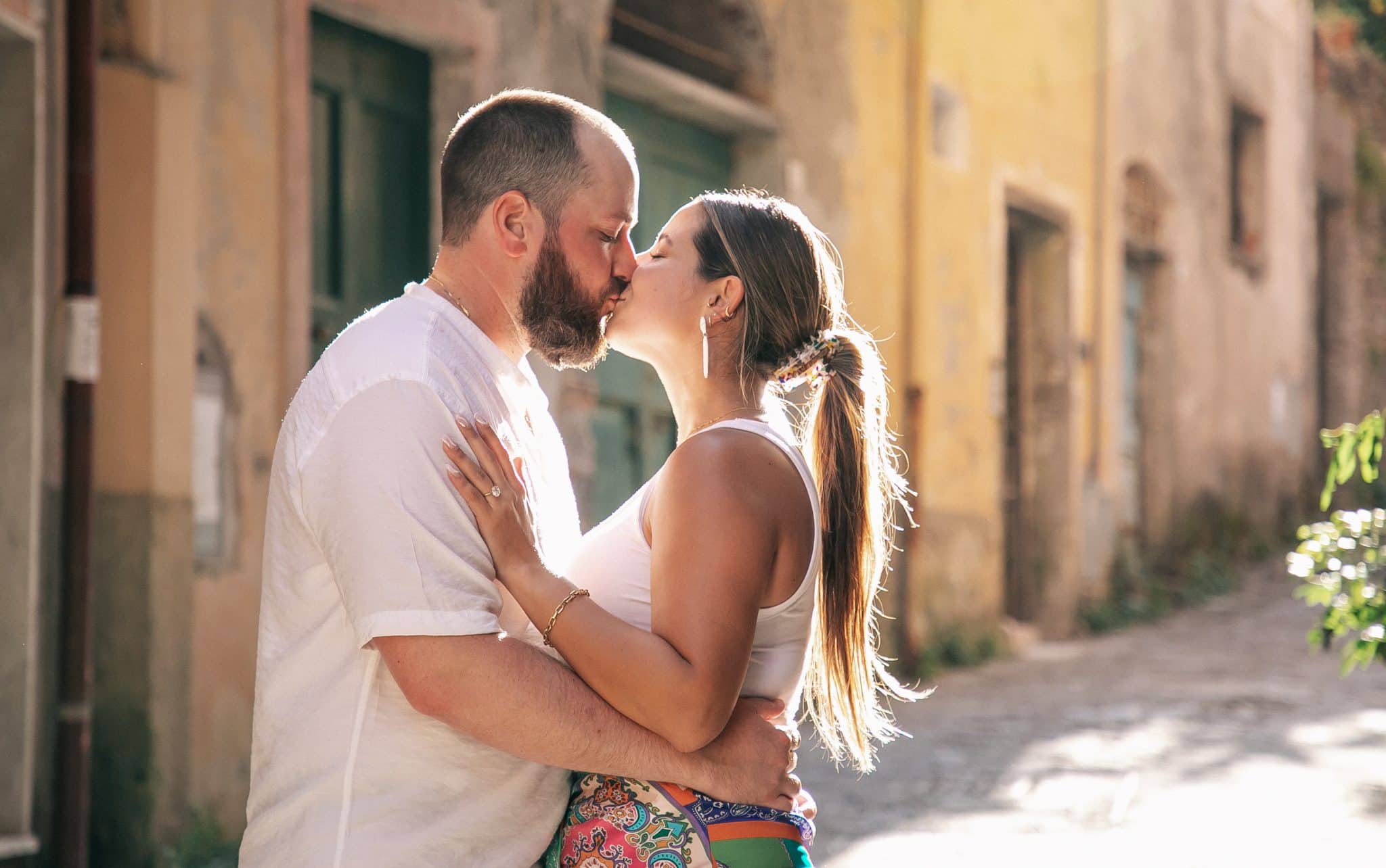 Newly engaged couple share a kiss on the streets of Italy