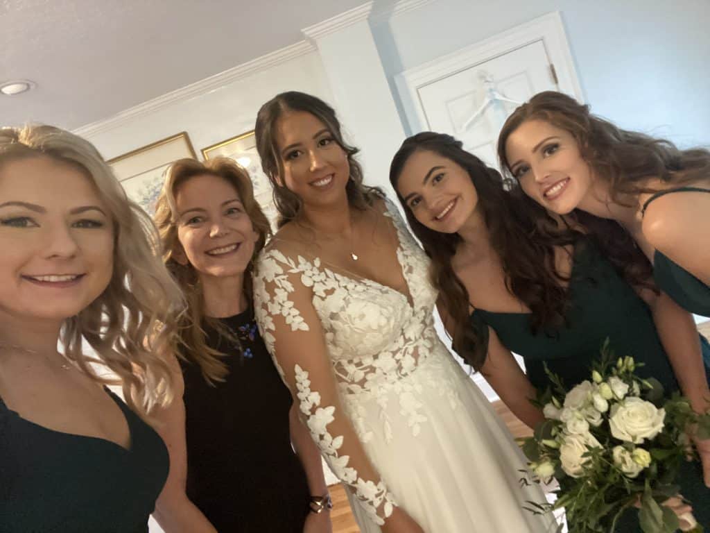 bride and bridesmaids smiling before wedding with officiant from Freebird Ceremonies