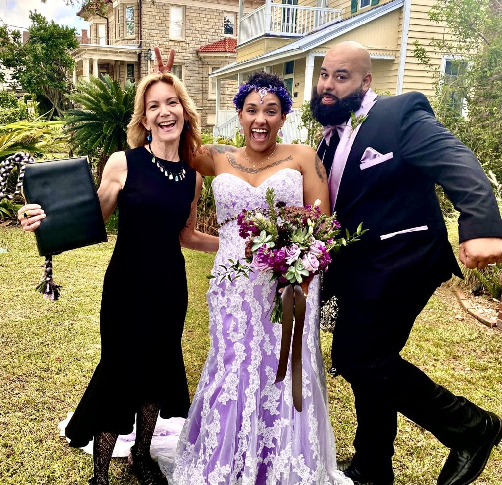 bride and groom in shades of lavendar with officiant from Freebird Ceremonies