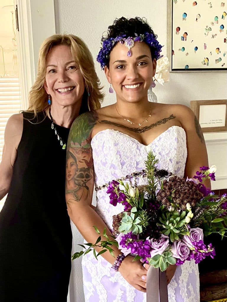bride with purple and green floral bouquet, tattoos and headband with officiant from Freebird Ceremonies