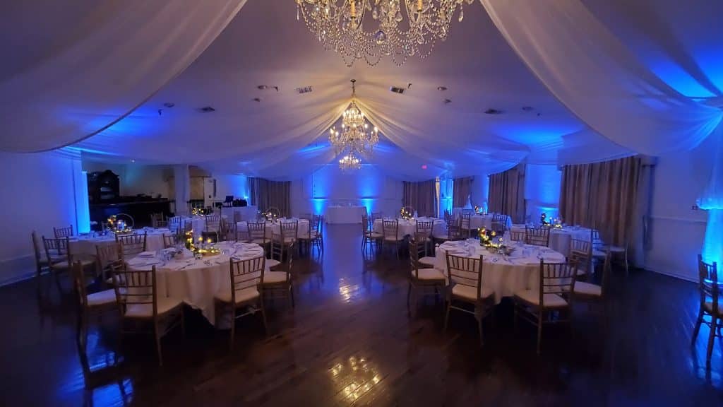 wedding reception with white ceiling drapes and chandeliers ready for music from Elegant Entertainment DJ and Video Services Orlando