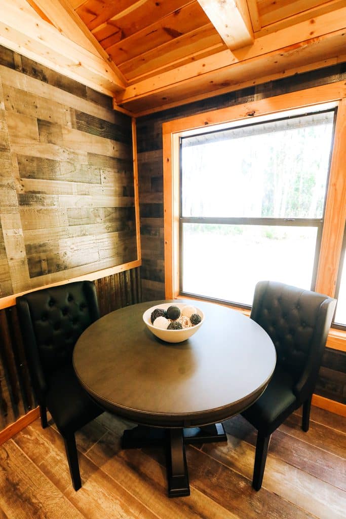 cozy round wooden table in corner against window at The Venue at Gentry Pines