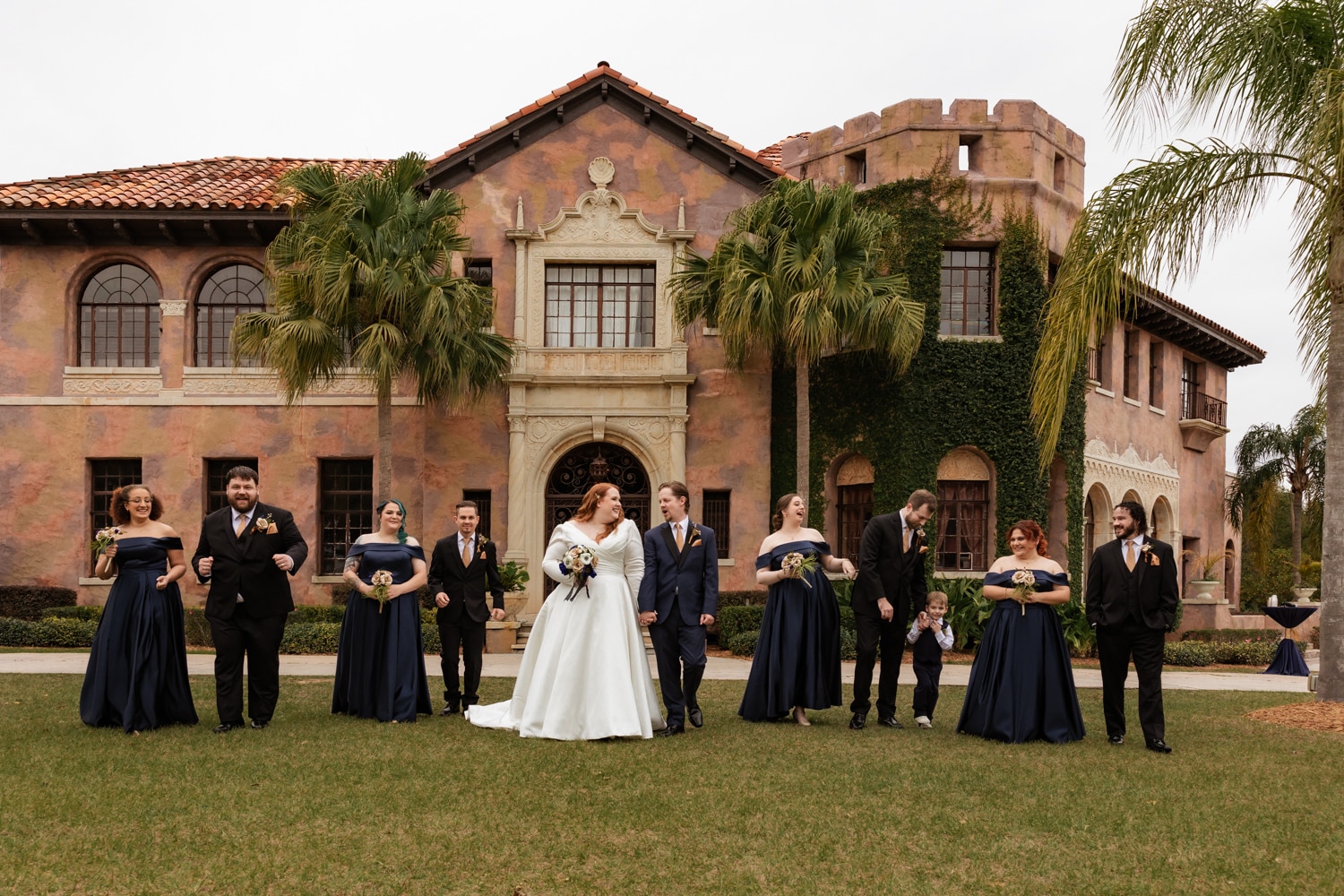 Newlyweds and bridal party stand in front of Florida wedding venue Howey Mansion