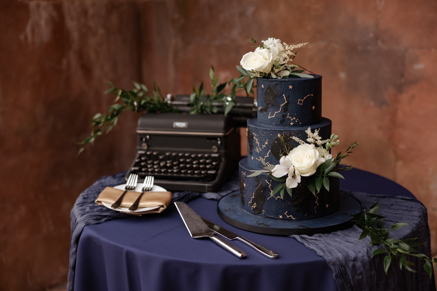 Custom designed deep blue wedding cake with constellation designs and white florals for celestial wedding at the Howey Mansion.