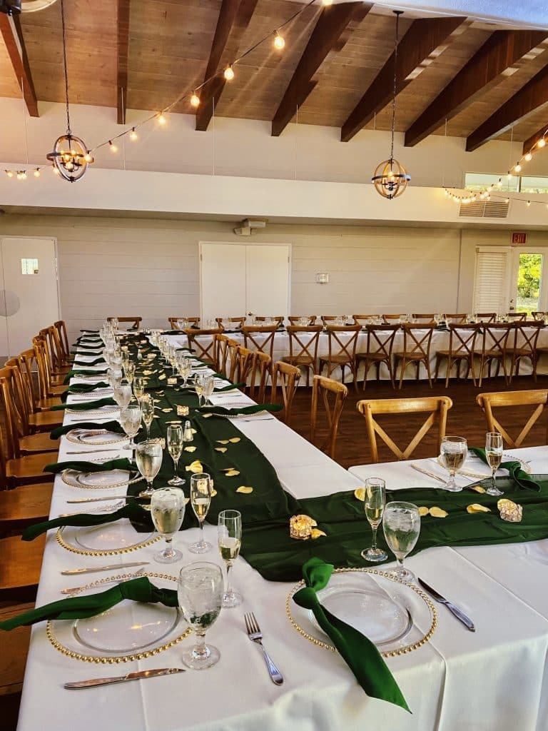 long tables set in a square at wedding reception under wooden beams and market lights at The Garden Villa