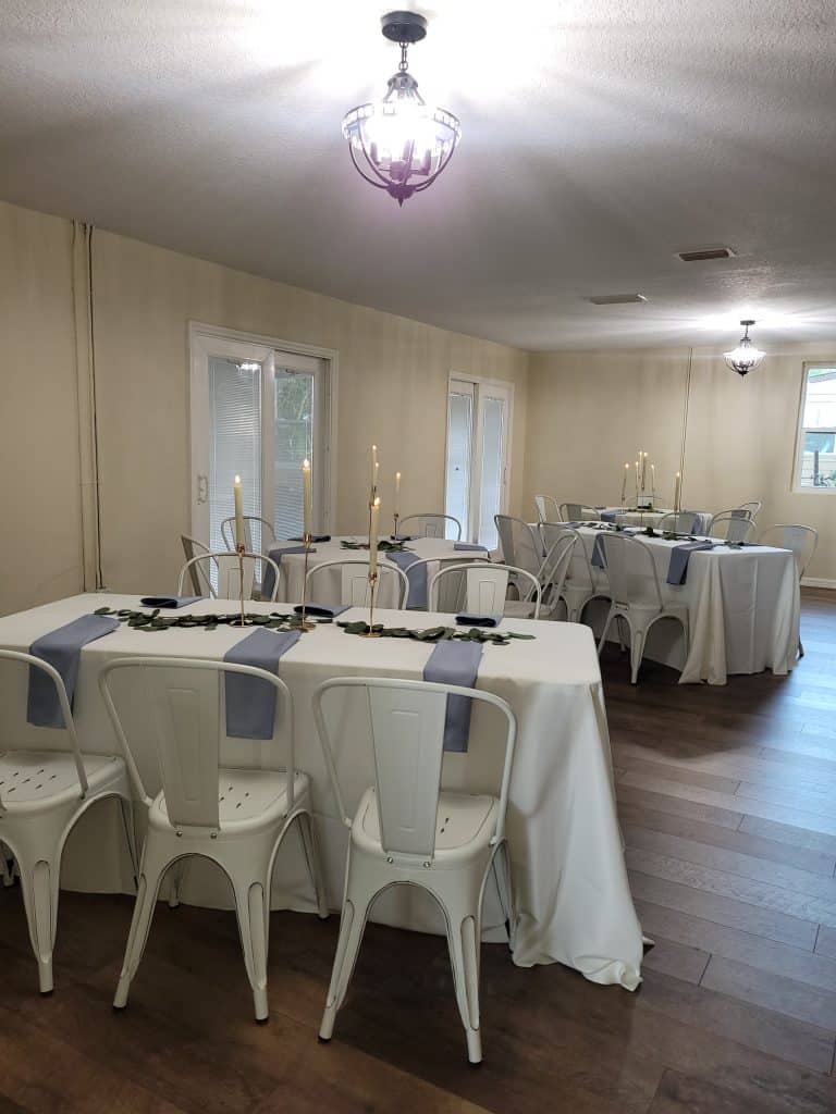 event space set-up with blue and white linens and chairs at The Lake House at Tropical Resort & Marina