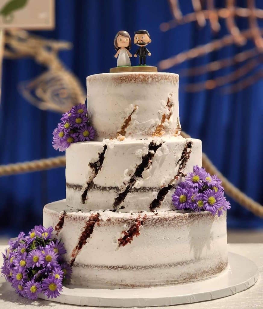 slashed wedding cake with lilac flowers by Cake & Bake