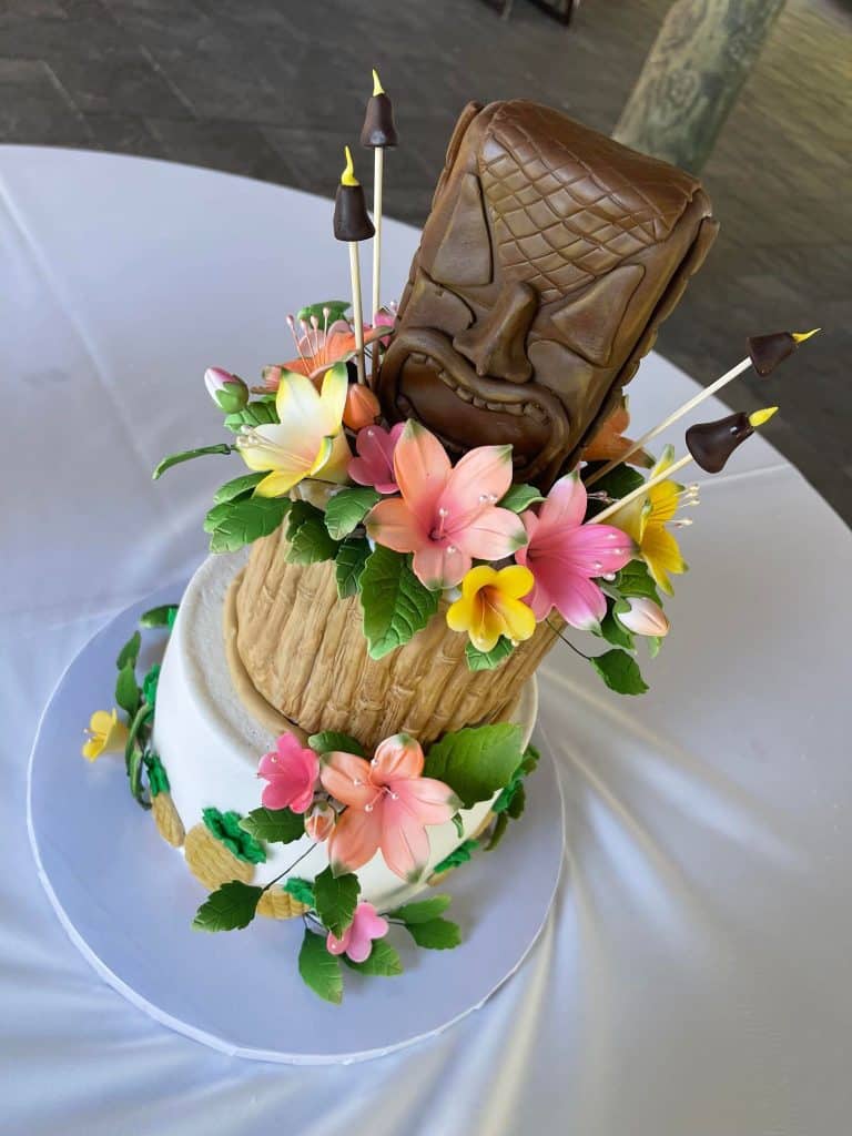 tiki head and tropical floral design wedding cake by Cake & Bake