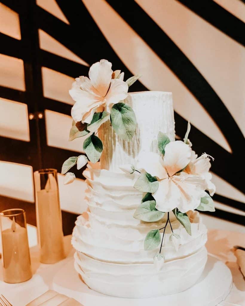 wedding cake with large white flowers and greenery by Cake & Bake