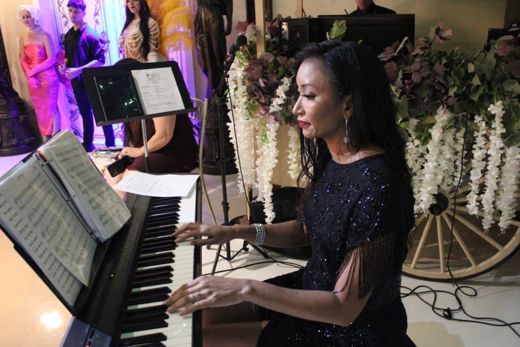 Deanna L. Giron - Singer & Pianist plays a piano during a show