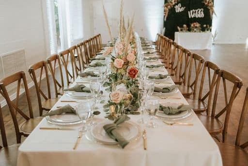 trestle table set with pink and cream flowers and green napkins at The Garden Villa