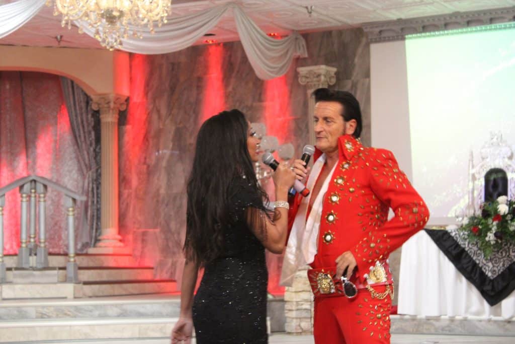 Deanna L. Giron - Singer & Pianist and an Elvis impersonator sing on stage