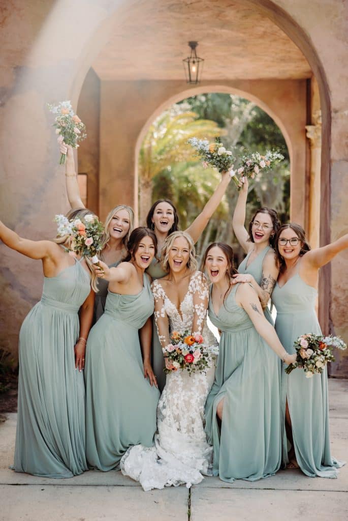 Bride with her bridesmaids under a stone arch