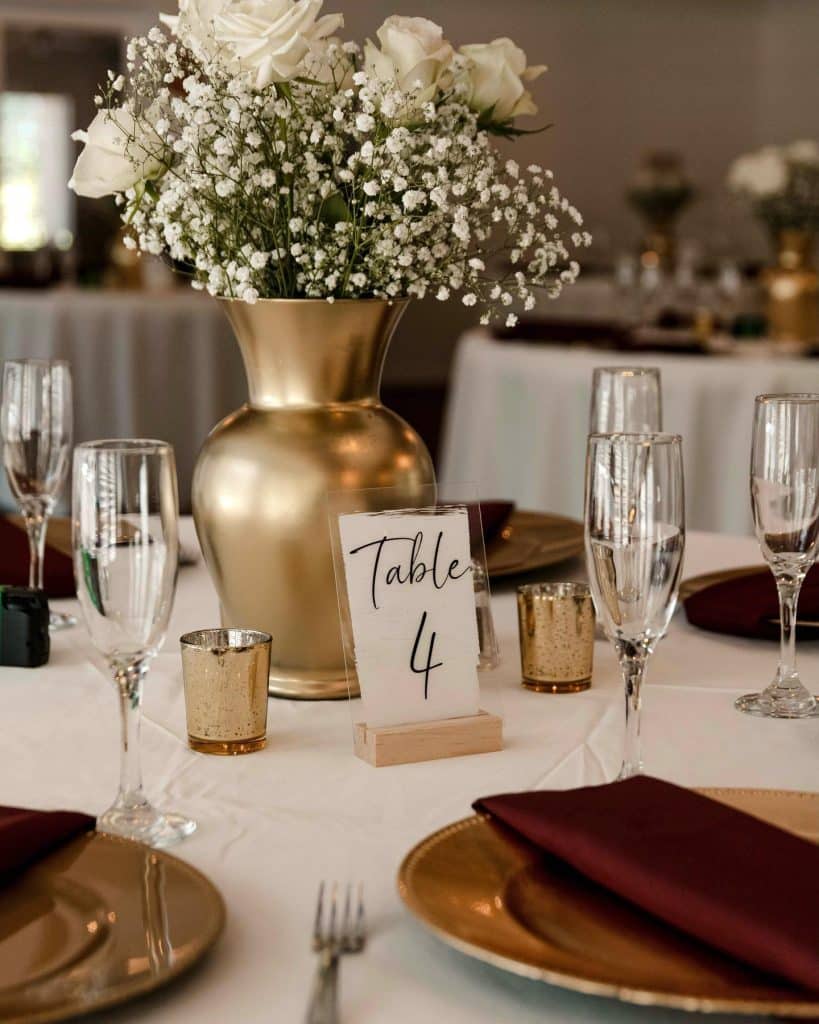 gold accents with white flowers on table number 4 at The Garden Villa