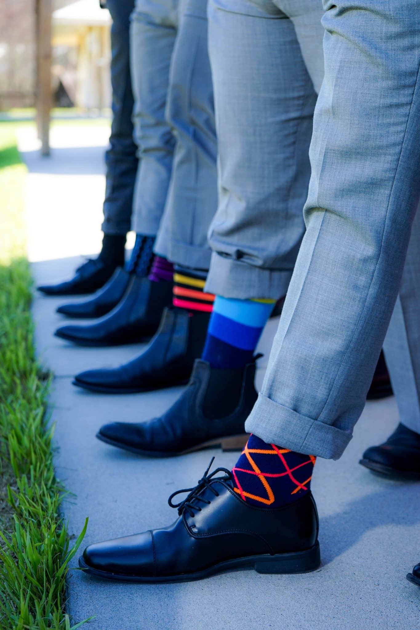 groom and groomsmen show off their black wedding day shoes and boots