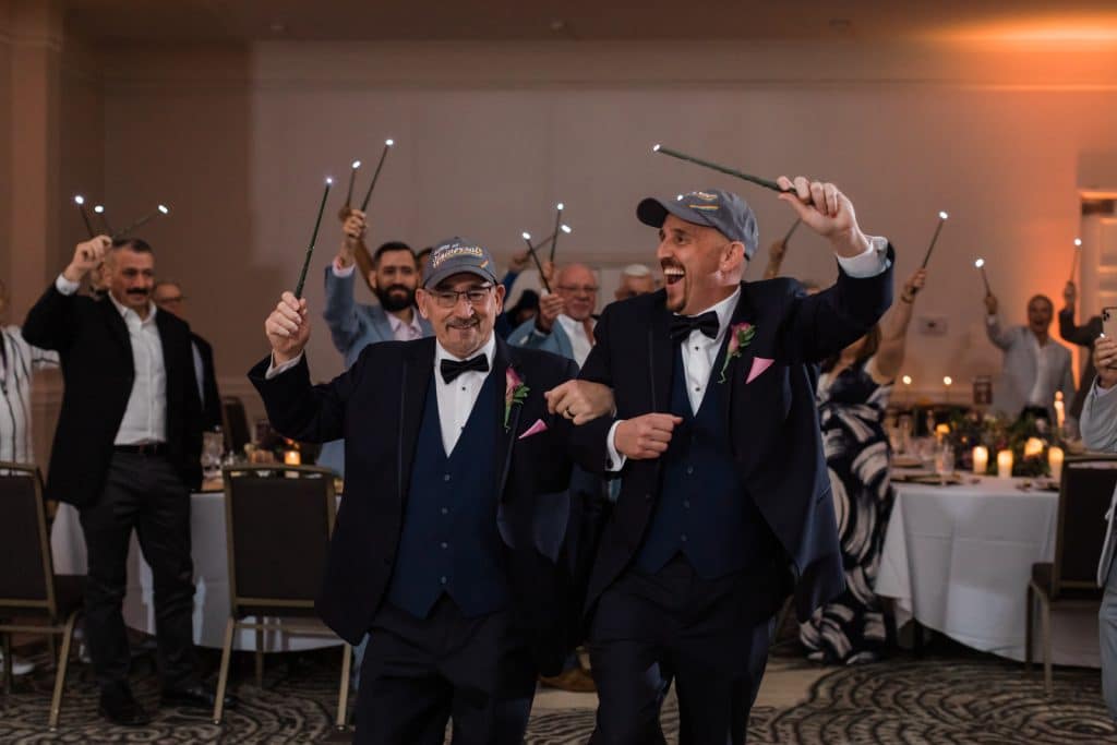 grooms sharing a dance with wizarding wands photographed by Ashley Jane Photography
