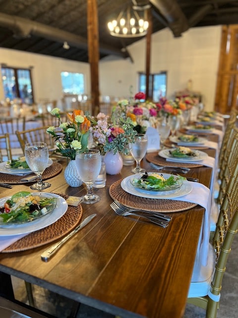 wooden farmhouse table set for wedding reception from Serve All Catering