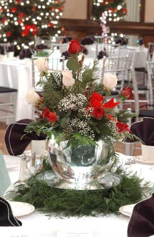 winter center pieces of evergreen, pine cones and red flowers in ice vases by Ice Pro