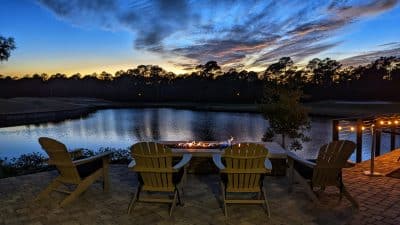 the golden hour of sunset over the lake with adirondack chairs to relax in at St. Johns Golf & Country Club