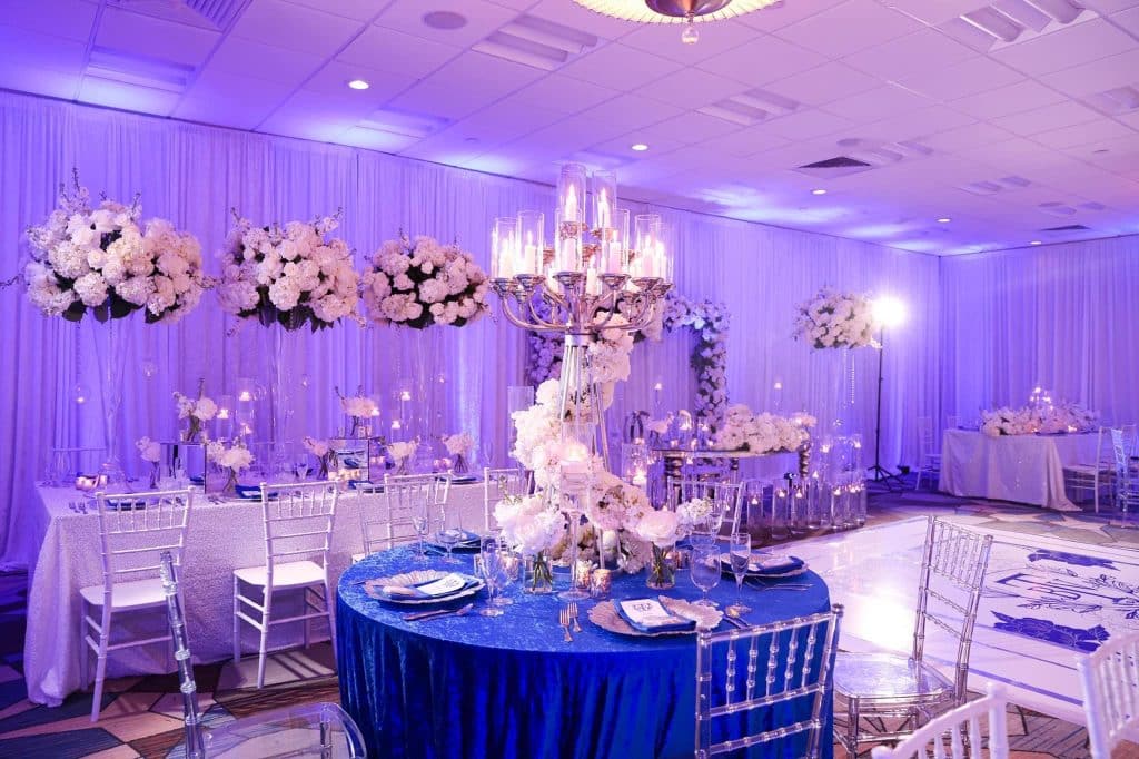 tall floral centerpieces and chandeliers with blue and white table accents coordinated by glameventdesigns