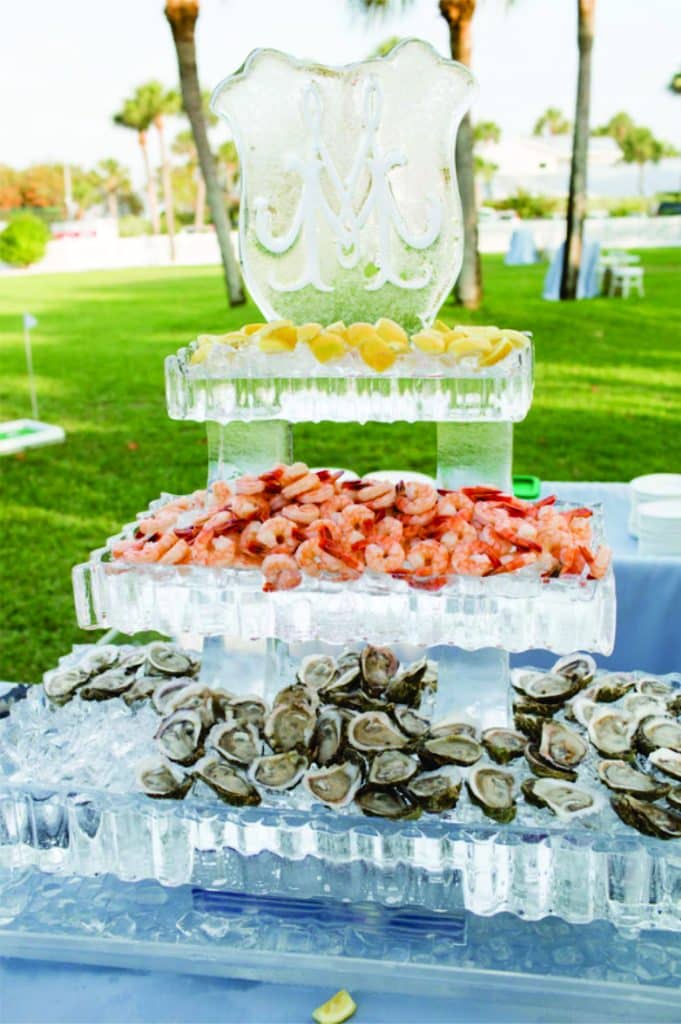 seafood bar with oysters ad shrimp on ice platters carved into by Ice Pro