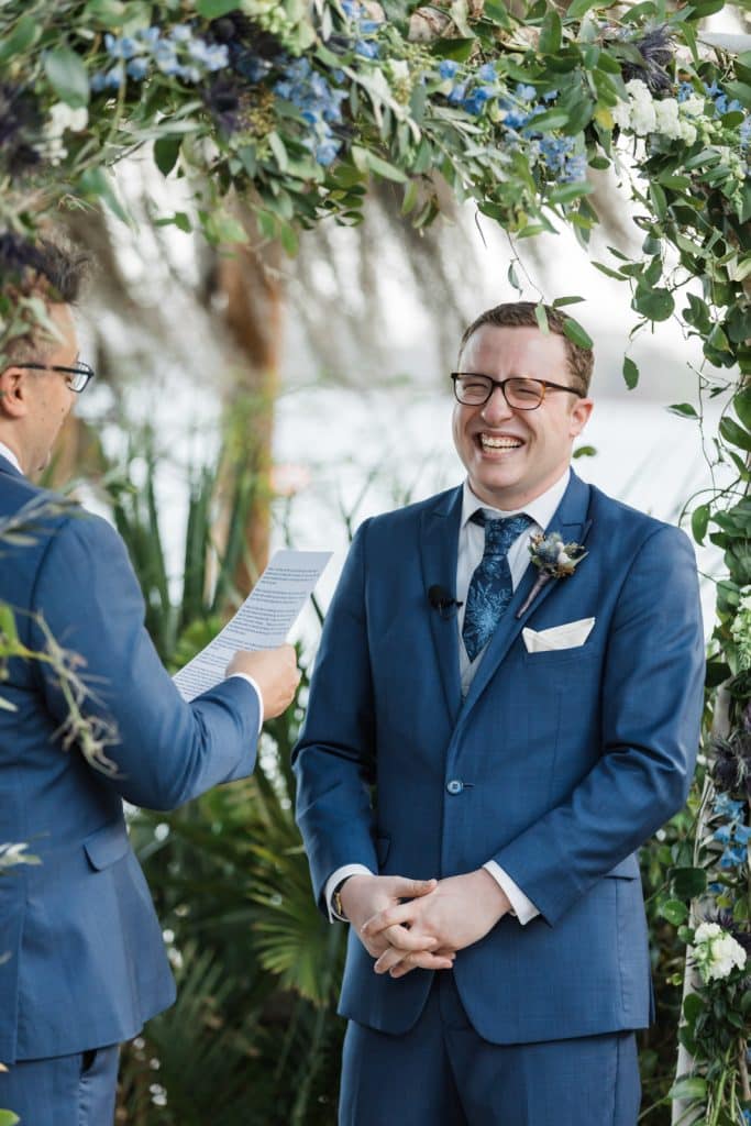 groom smiling at officiant photographed by Ashley Jane Photography